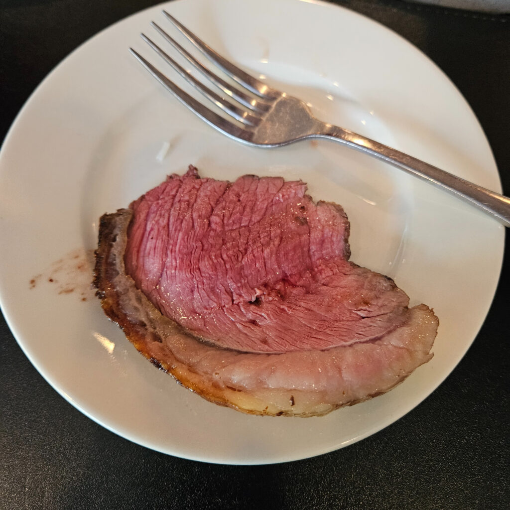 Top sirloin steak on a plate with a fork.