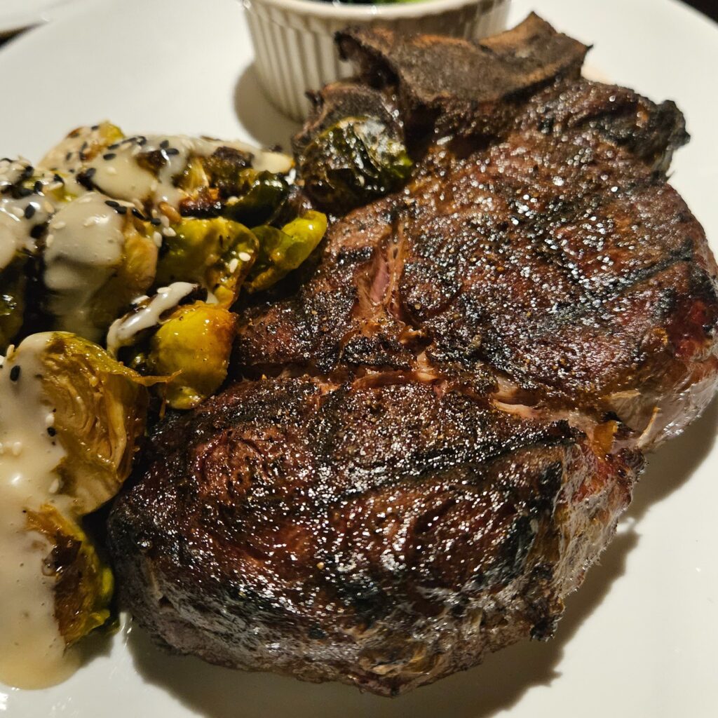 Ribeye steak on a plate with brussels sprouts.