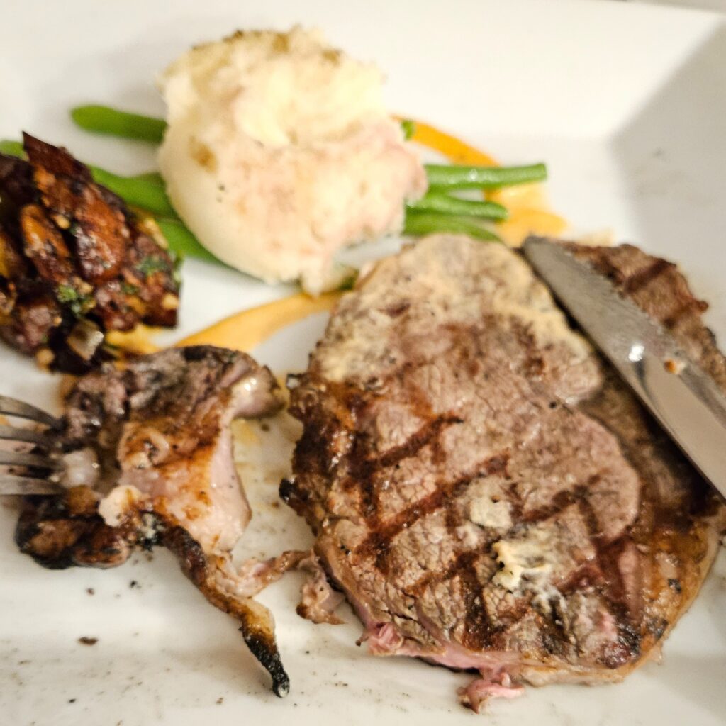 Ribeye steak with mashed potatoes on a plate.