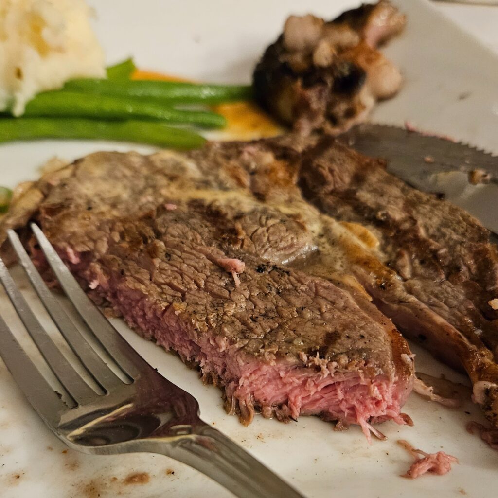 Medium grilled ribeye on a plate with fork.