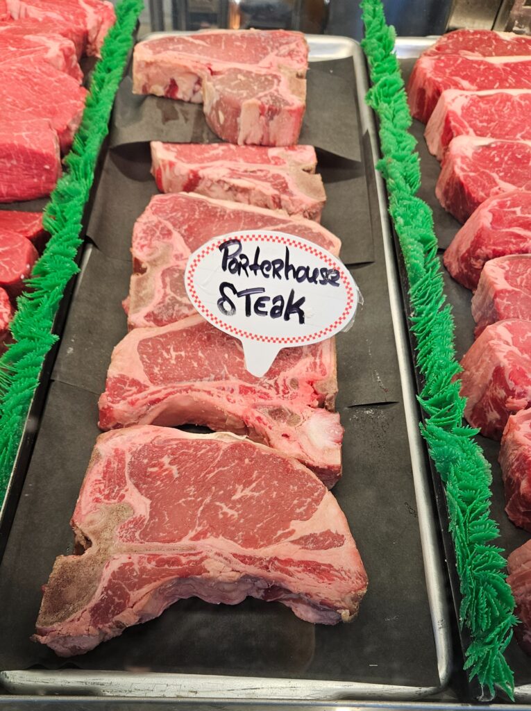 Porterhouse steak displayed on a meat counter.