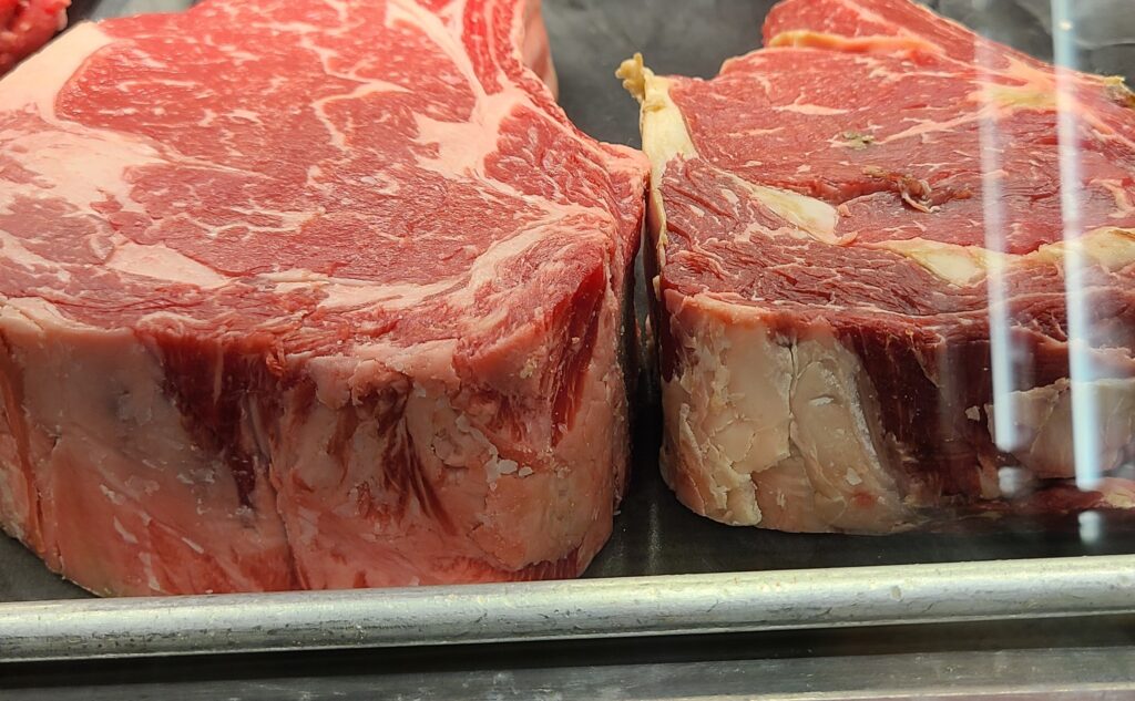 Close up view of marbling in raw cuts of steak.