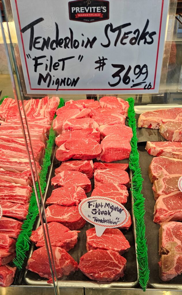 Filet mignon steak displayed on a meat counter with price.