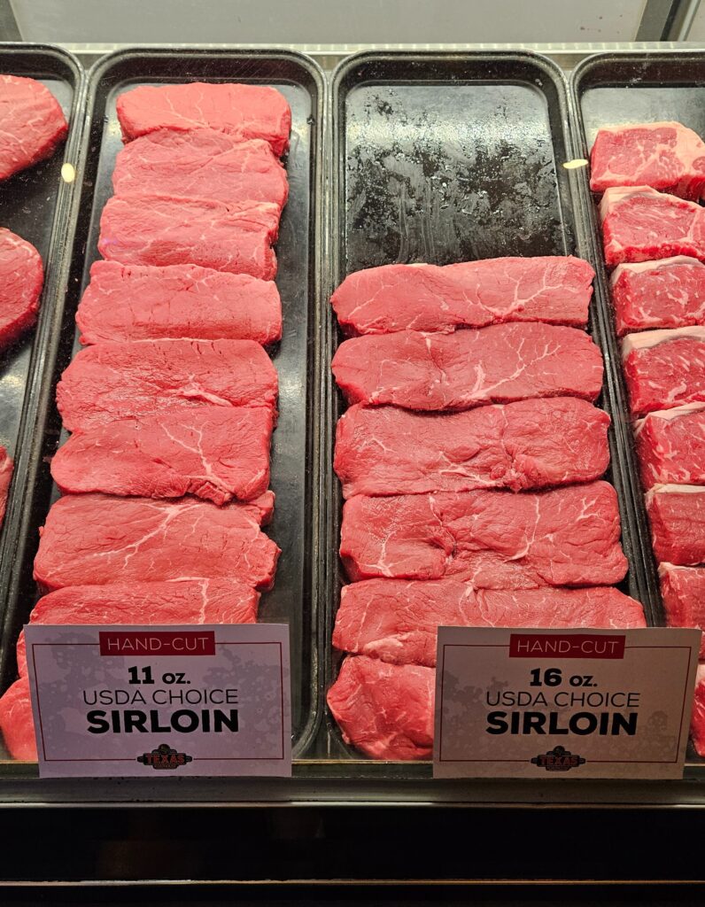 Sirloin steak cuts displayed on a meat counter.